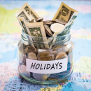 Jar filled with money labeled HOLIDAYS